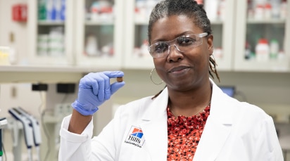 Hill's Pet profesionalac drži granule hrane za kućne ljubimce u ruci.